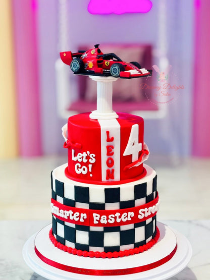Two-tiered birthday cake with a race car on top, featuring the text 'Let's Go! Leon 4' and a checkered pattern.