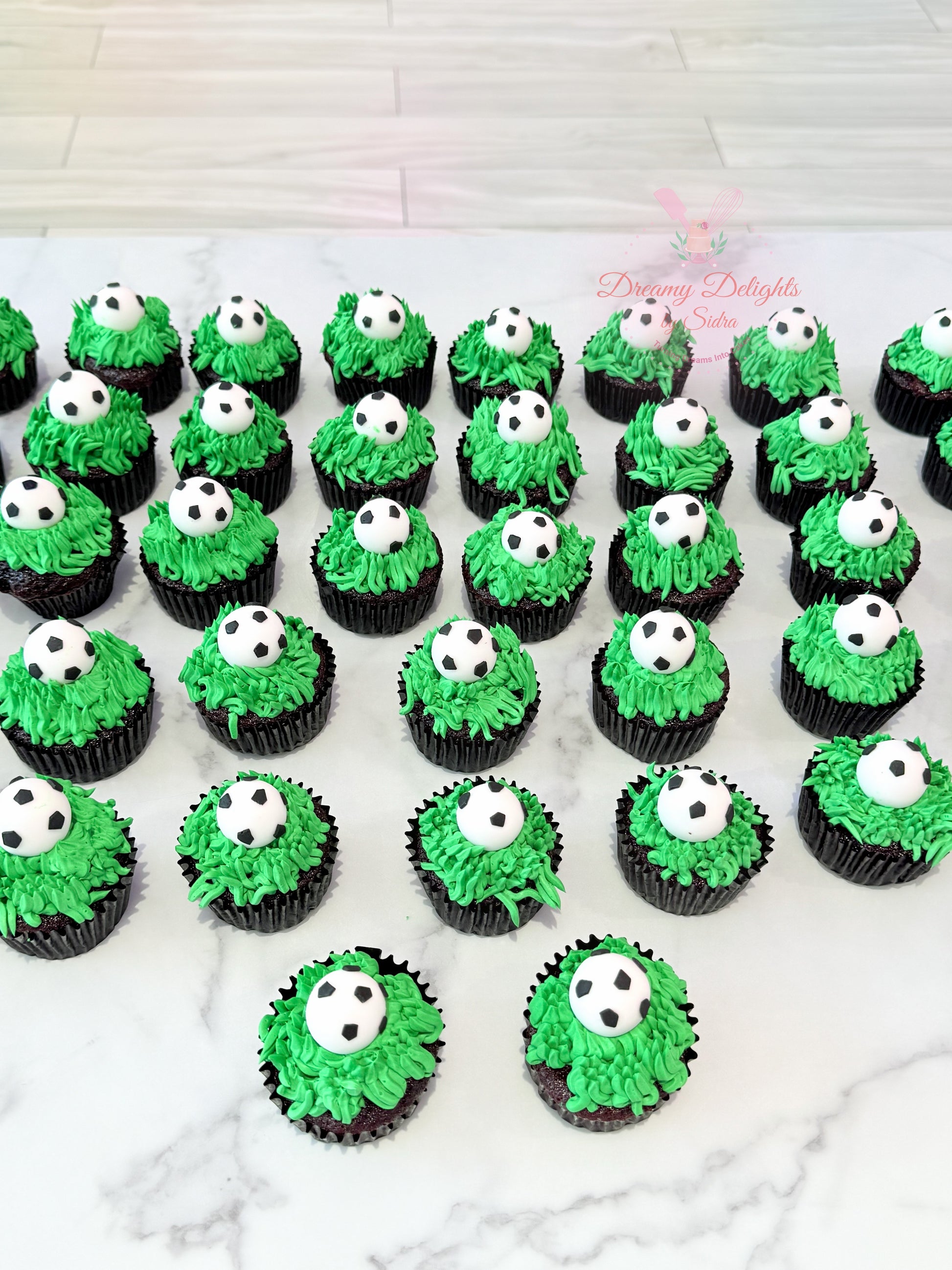 Football themed cupcakes with green grass frosting and soccer ball toppers for kids parties