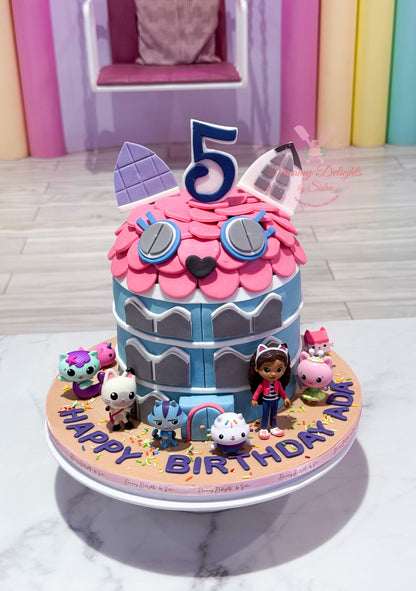 Gabby's Dollhouse cake Dubai with pink frosting, colourful jewels, heart decorations and cute bunny topper by Dreamy Delights by Sidra.