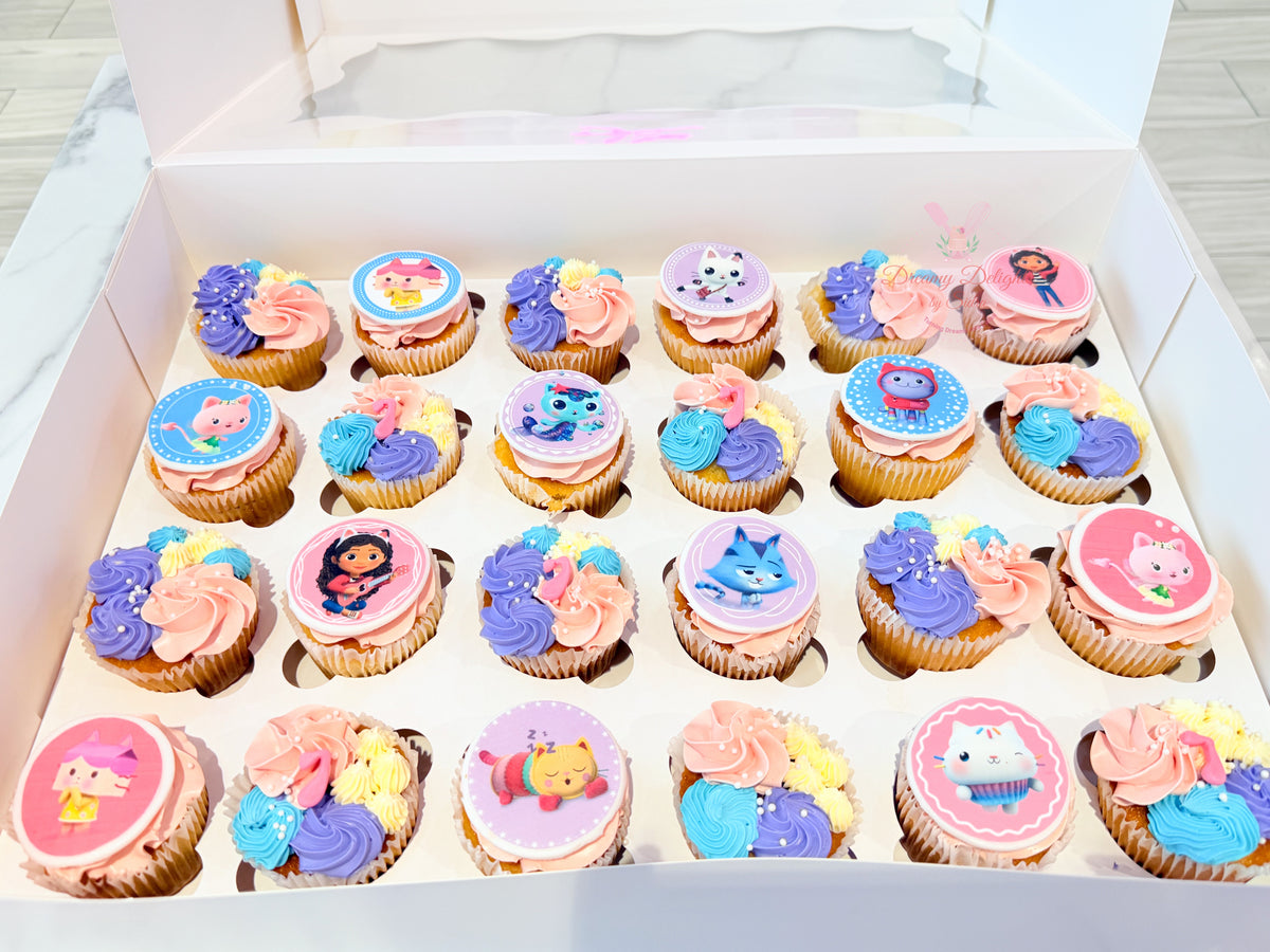 Gabby's Dollhouse cupcakes with colourful character toppers and pink, purple and blue buttercream swirls for kids' birthday celebrations by Dreamy Delights by Sidra in Dubai.