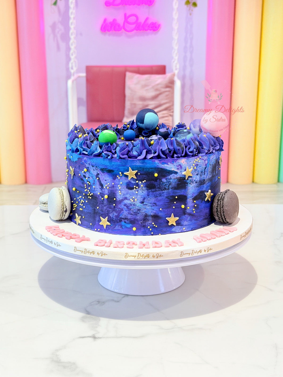 Galaxy Planets Cake with blue and purple galaxy frosting, colourful planet decorations and golden stars in Dubai
