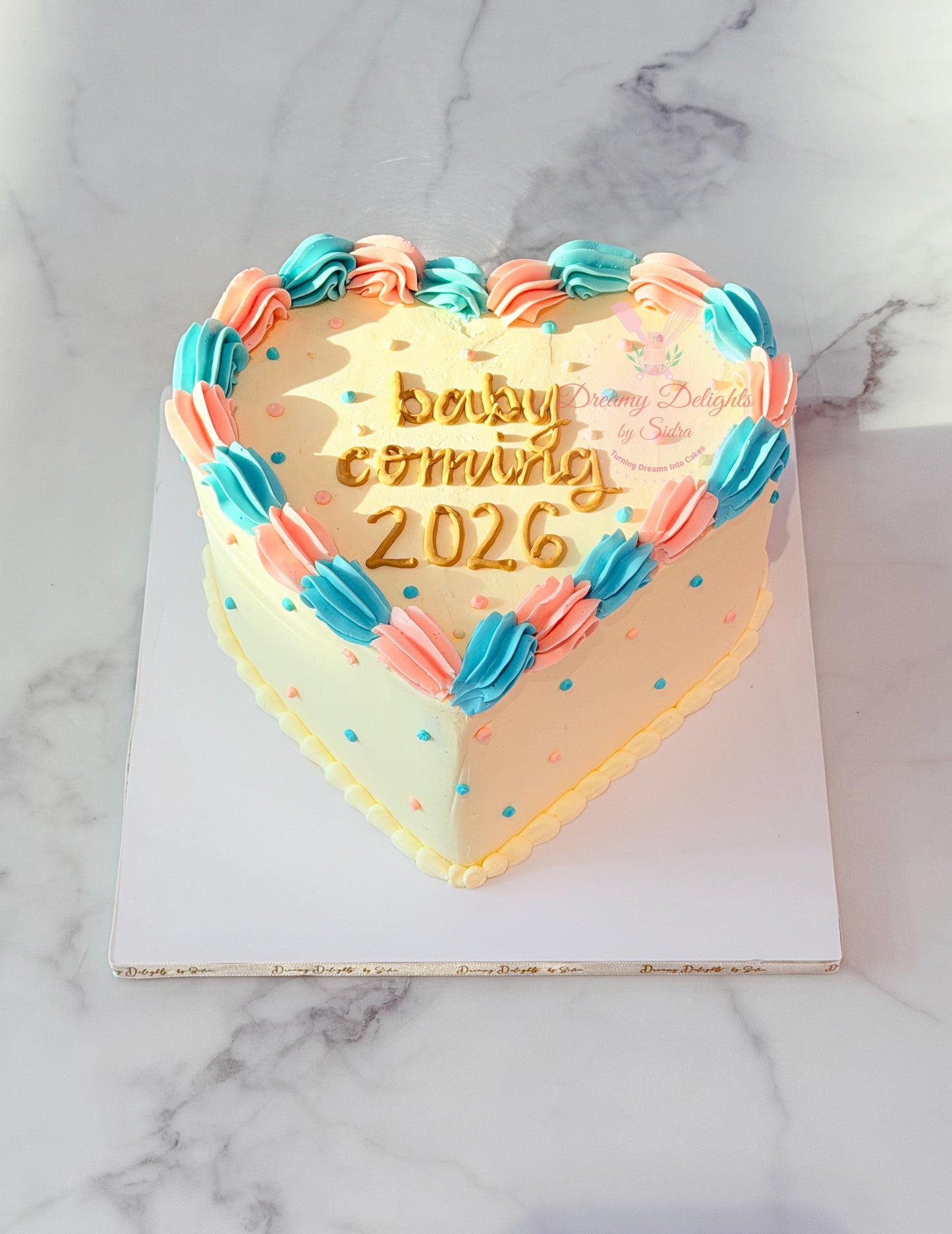 Vintage heart gender reveal cake with pink and blue buttercream piping and personalized baby shower message in Dubai.