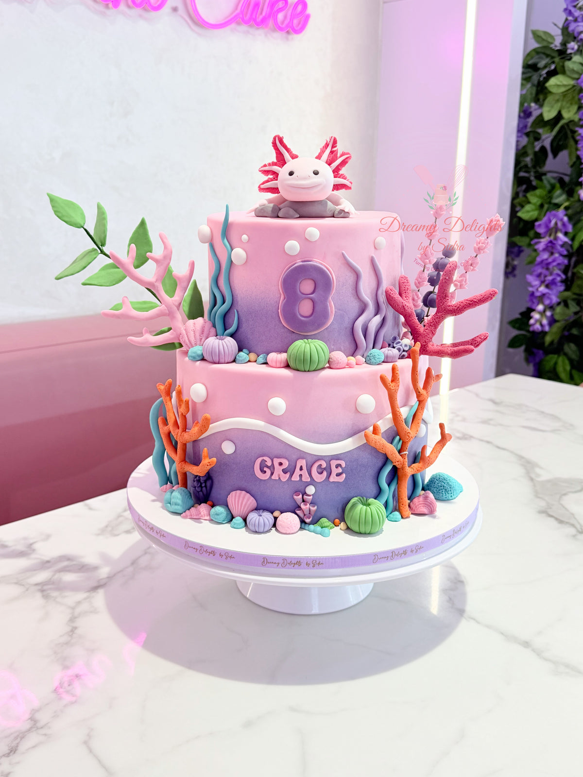 Girls birthday cake Dubai with a cute axolotl theme, colourful coral and personalised details. Explore kids cake Dubai and order online today!