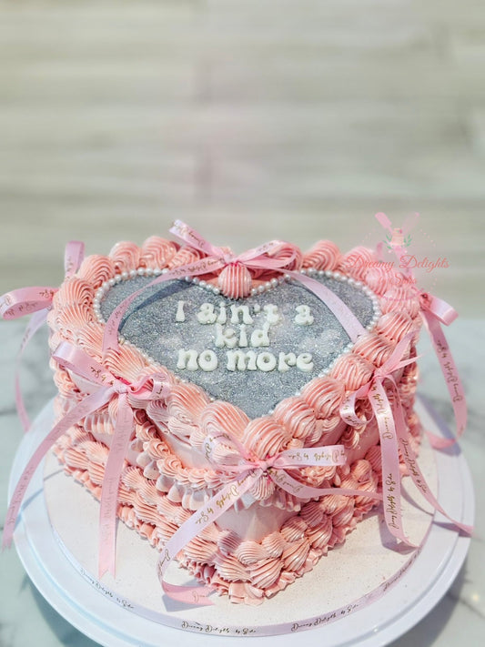 Heart-shaped cake with pink ribbons and a message on a light background