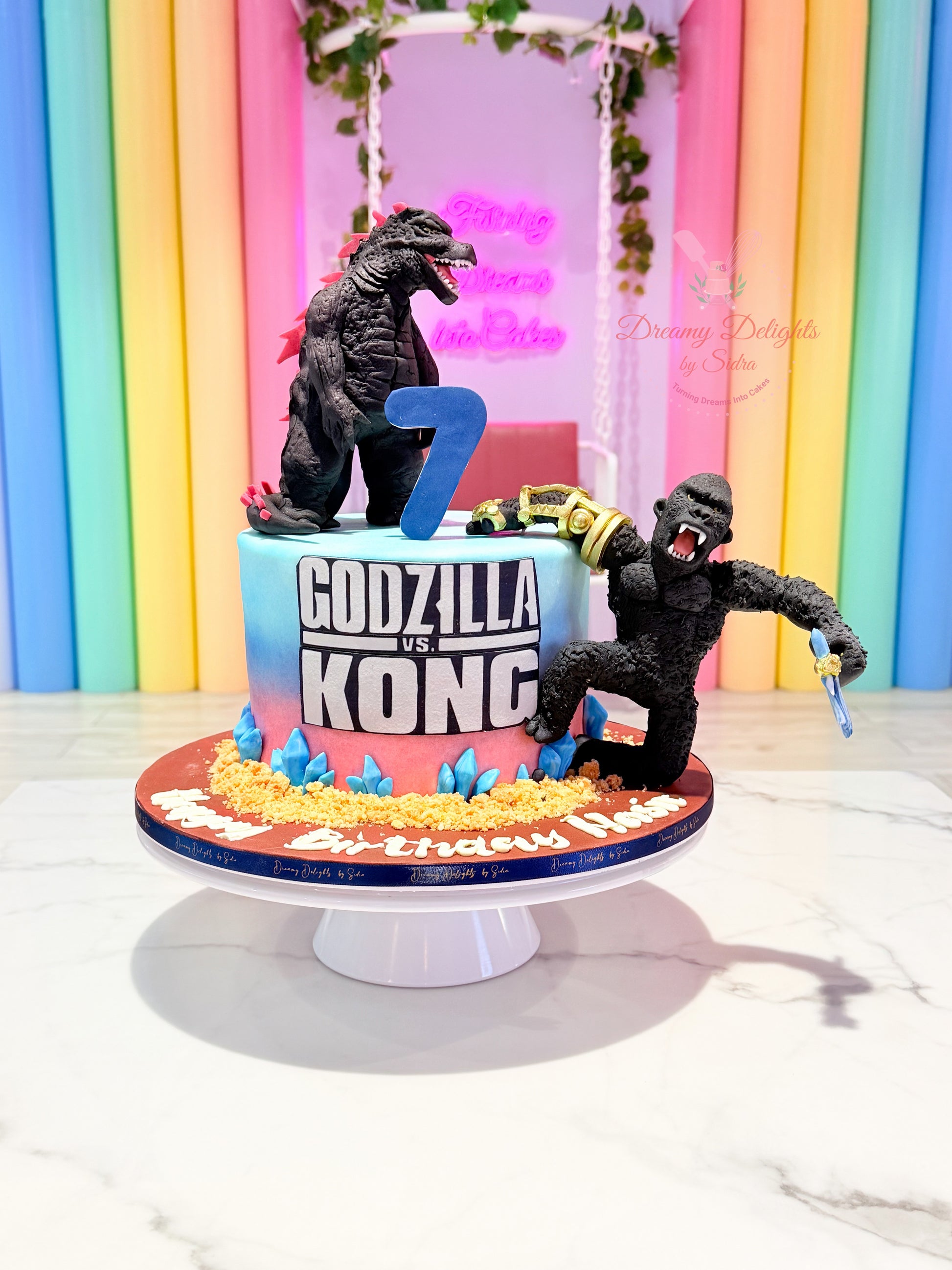 Godzilla vs Kong cake with 3D figures and custom number design for boys birthday celebration