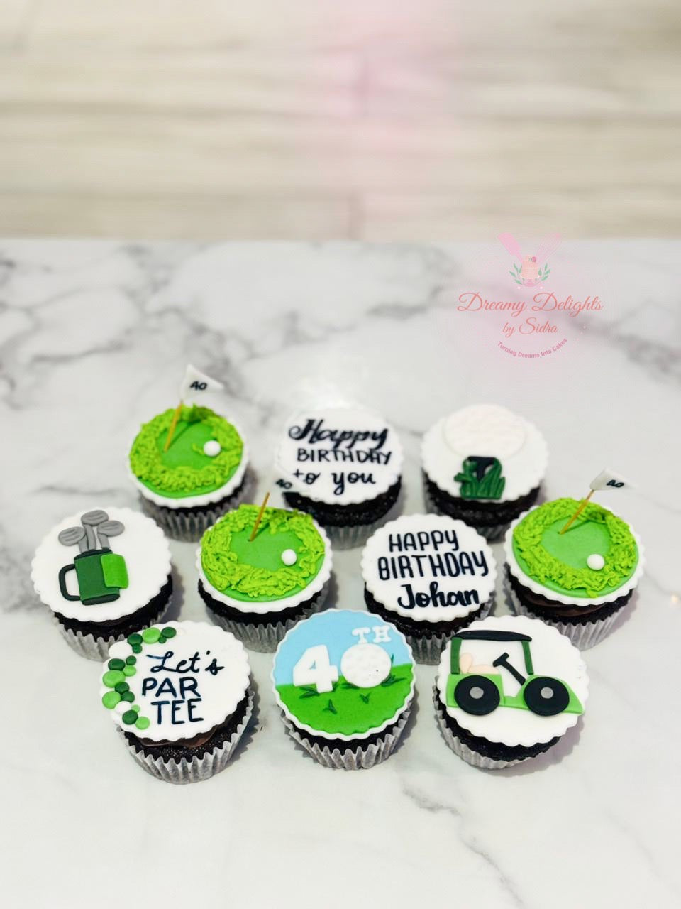 Golf-themed cupcakes on a marble surface with 'Happy Birthday' and other text