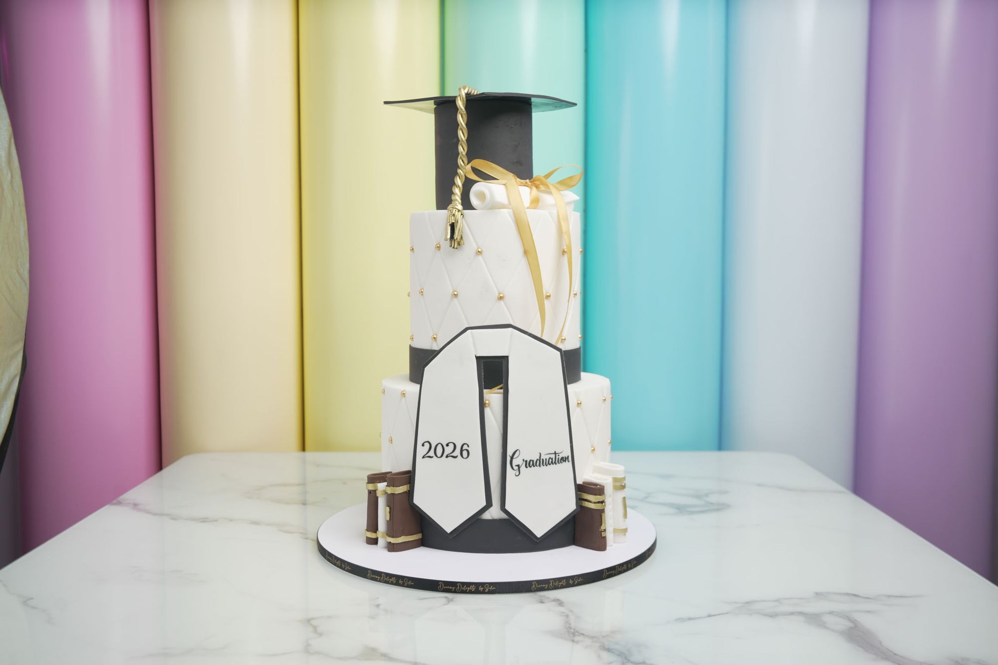 Elegant Graduation 2026 cake with graduation cap, diploma scroll, tassel, and personalized graduation decorations for graduation celebrations.