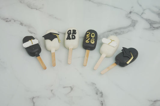 Graduation cakesicles decorated with graduation caps, diplomas, and Class of 2026 details for graduation celebrations in Dubai