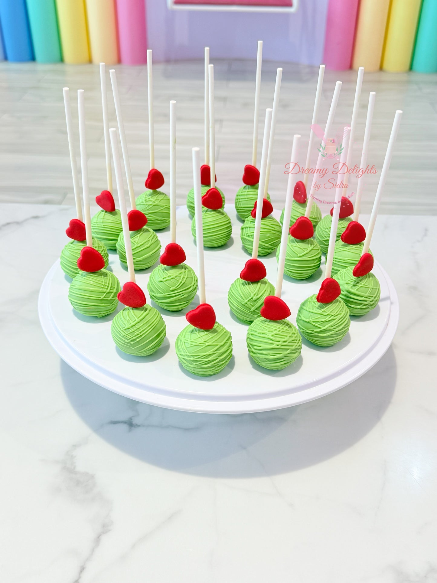 Green heart cake pops with edible heart toppers for birthdays, weddings, baby showers and celebrations in Dubai.