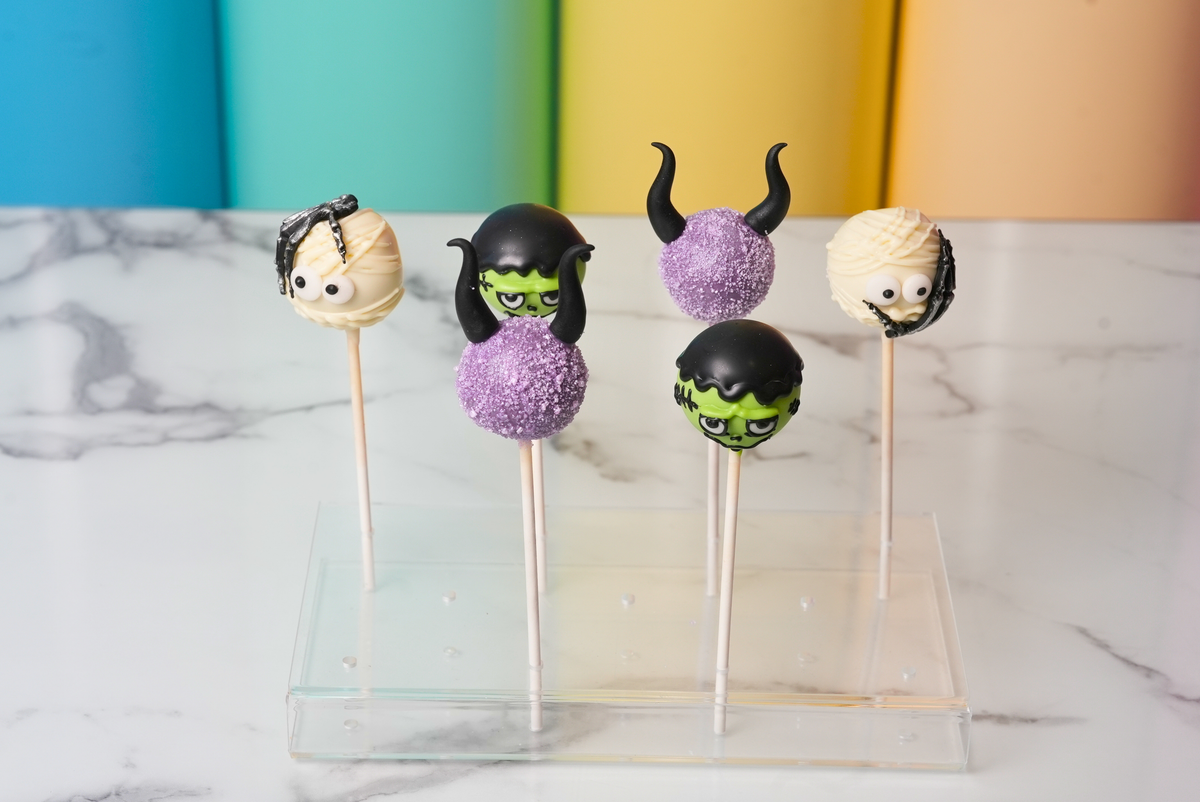 Halloween cake pops decorated as Frankenstein, mummies, and purple witch-inspired characters by Dreamy Delights by Sidra in Dubai.