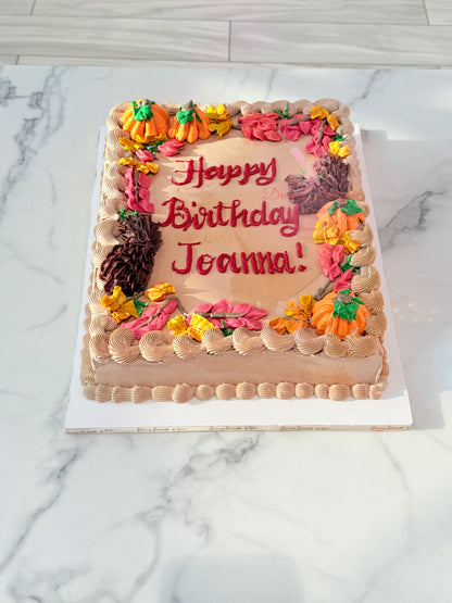 Halloween pumpkin sheet cake with handcrafted buttercream pumpkins, autumn leaves, and personalized birthday message in Dubai.
