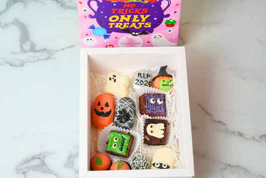 Halloween RIP Treat Bundle with ghost and pumpkin cake pops, spiderweb treats, mummy decorations, and spooky brownies by Dreamy Delights by Sidra in Dubai.