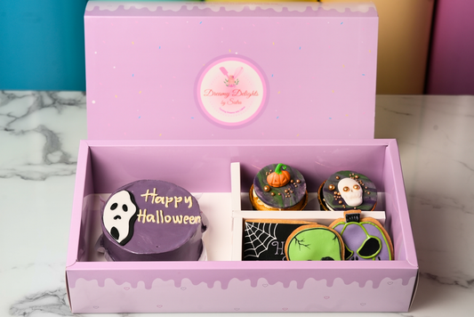 Halloween Skull Bento Bundle with a purple ghost cake, decorated cupcakes, and spooky cookies by Dreamy Delights by Sidra in Dubai.