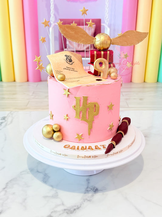 Harry Potter cake Dubai with pink frosting, golden snitch, Hogwarts letter and magical wand by Dreamy Delights by Sidra
