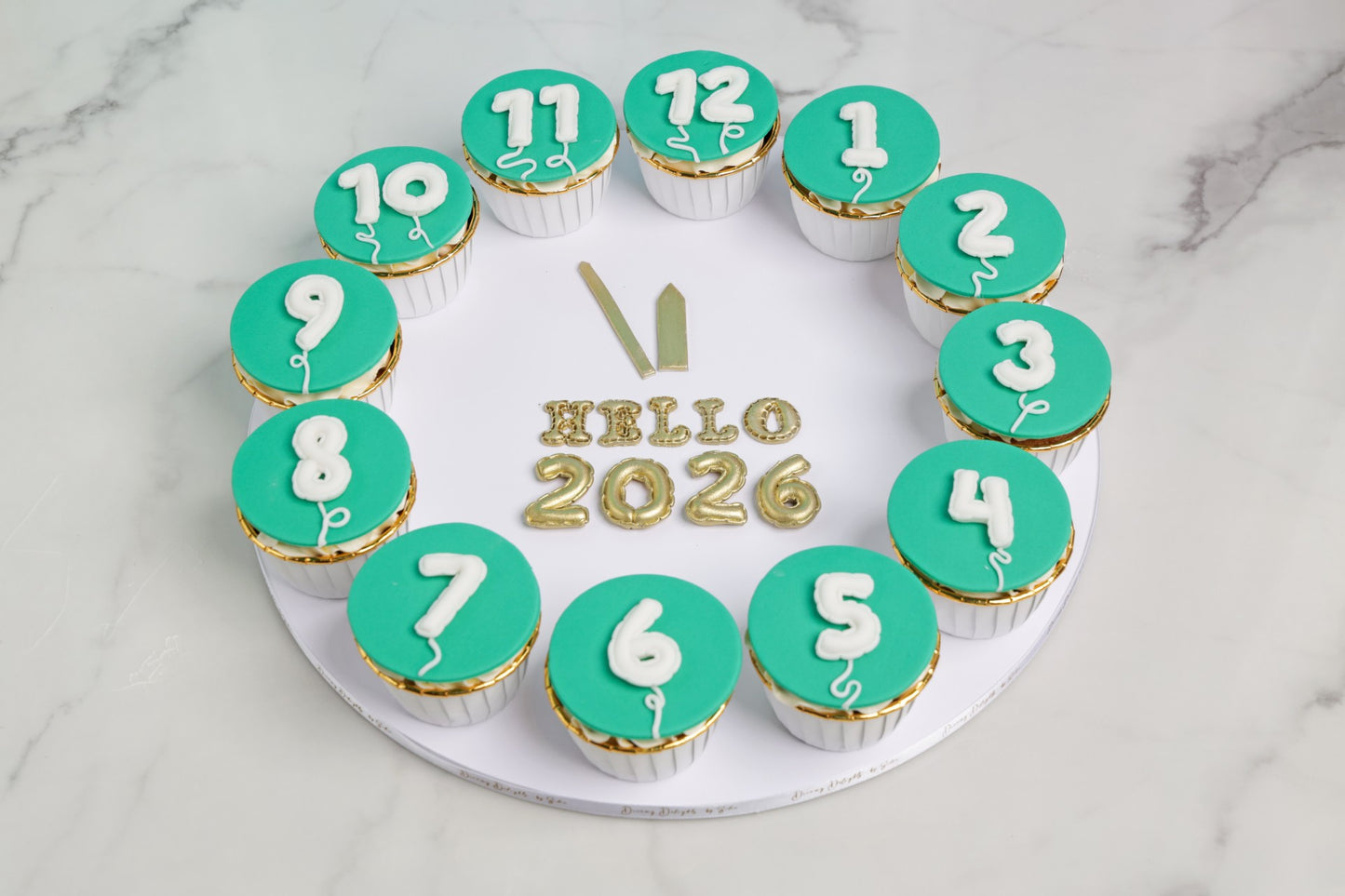 Hello 2026 balloon cupcakes arranged in a countdown circle by Dreamy Delight by Sidra