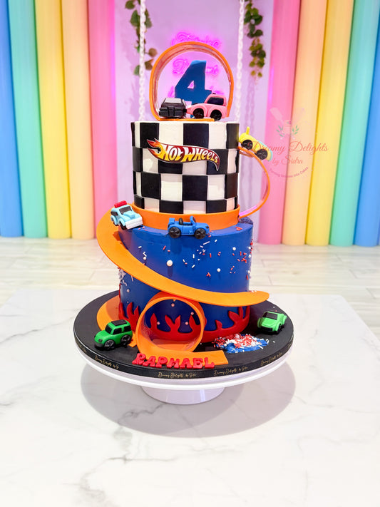 Hot Wheels birthday cake Dubai with racing cars, orange racetrack and chequered flag design by Dreamy Delights by Sidra