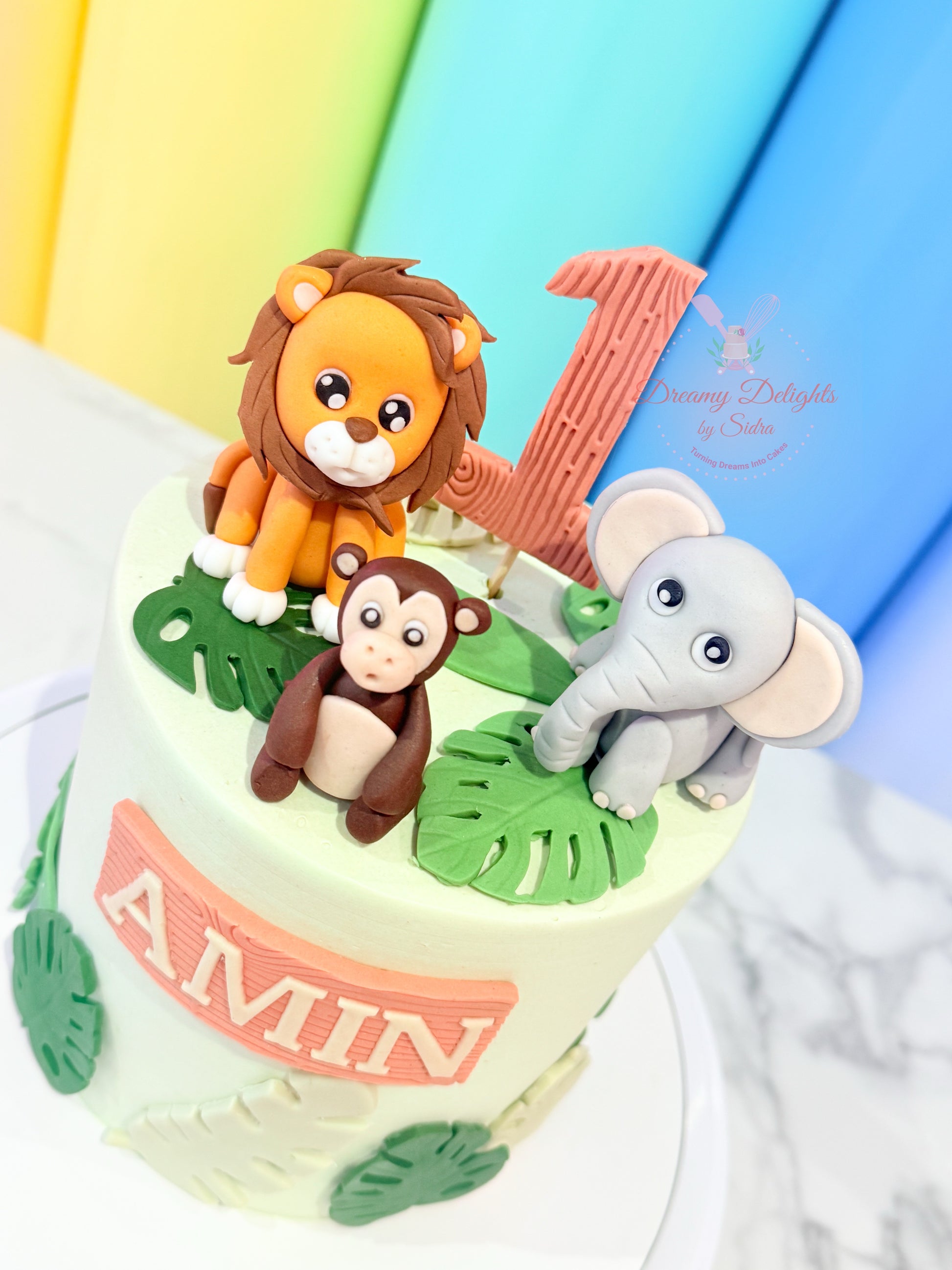 Small cake with lion, monkey, and elephant figurines on a colorful background