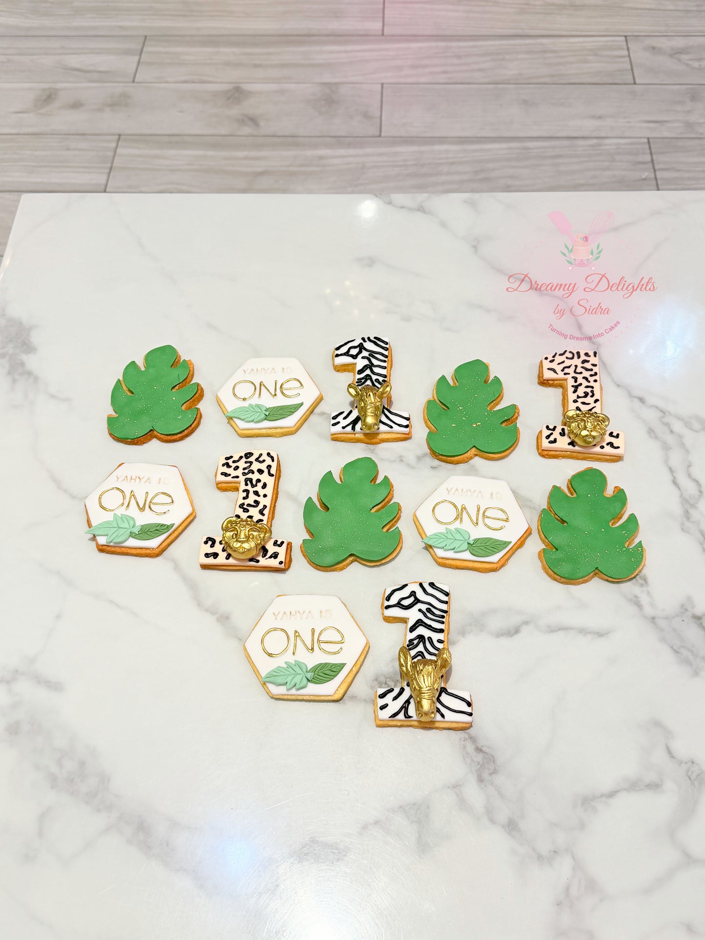 Jungle first birthday cookies with safari leaves, number one cookies and wild one theme decorations in Dubai