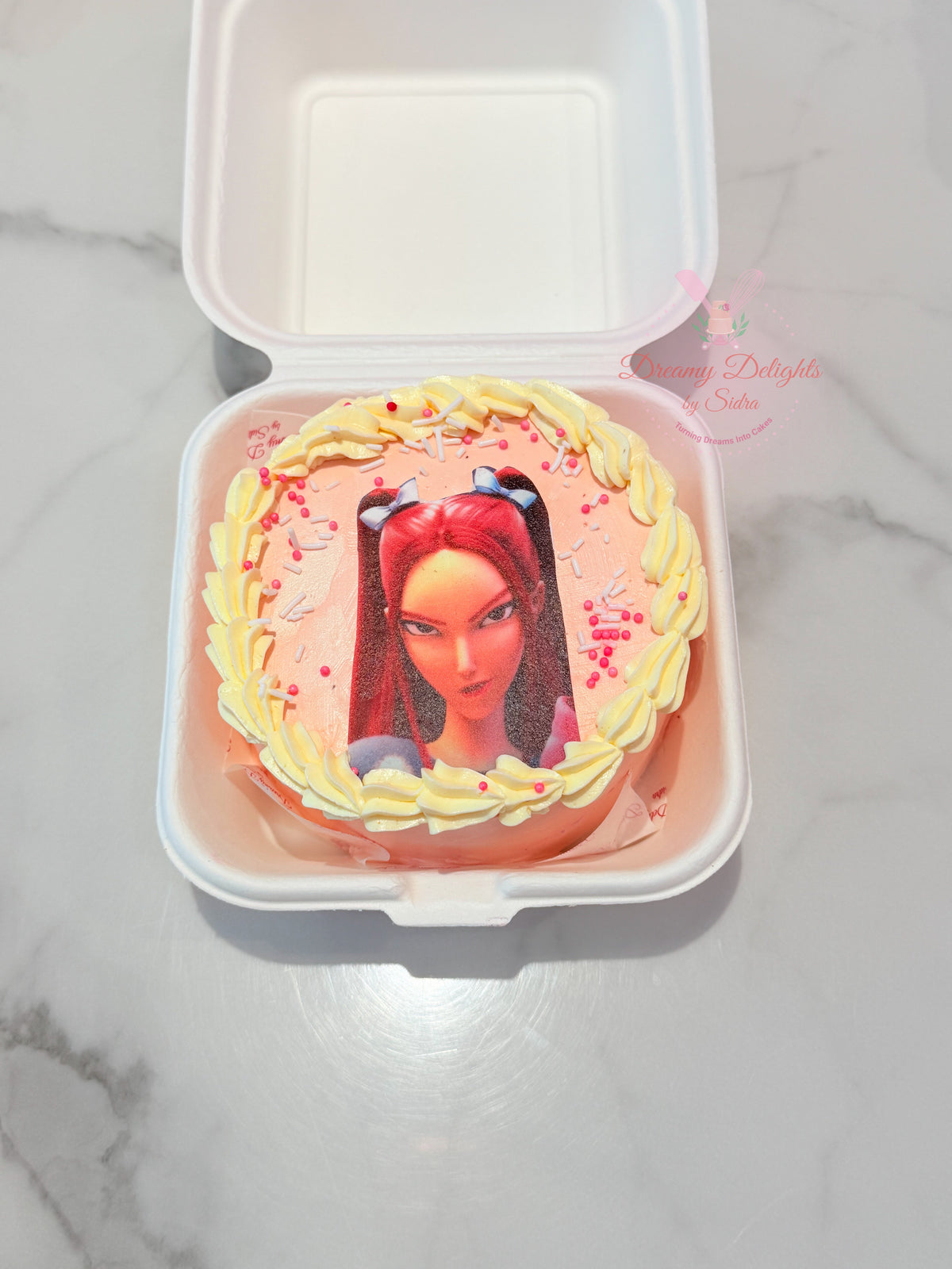 KPop Mira Bento Cake with pink frosting, character image, yellow piped border and colourful sprinkles in Dubai