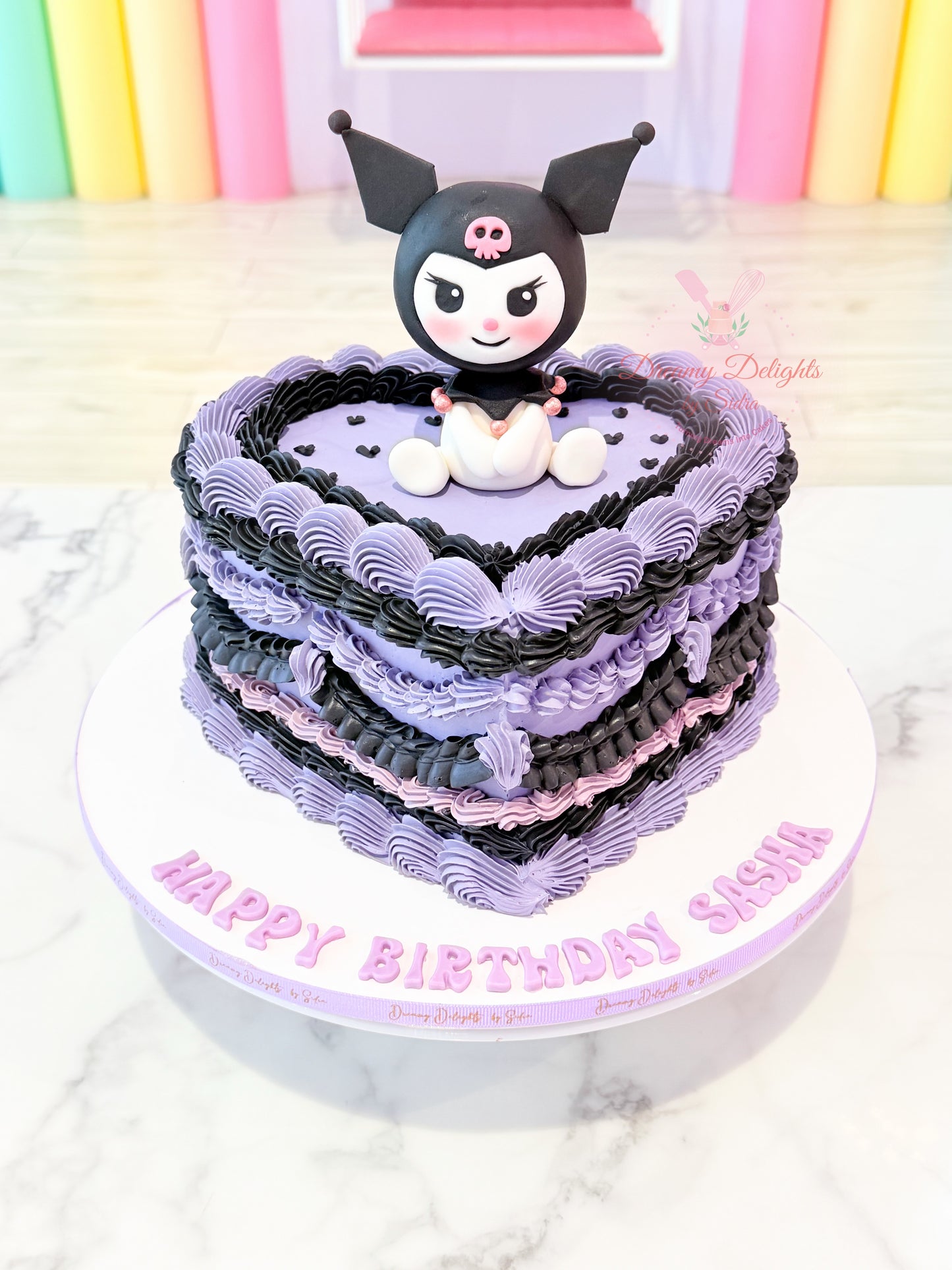 Heart-shaped Kuromi birthday cake with purple and black buttercream piping and handcrafted Sanrio topper for girls in Dubai.