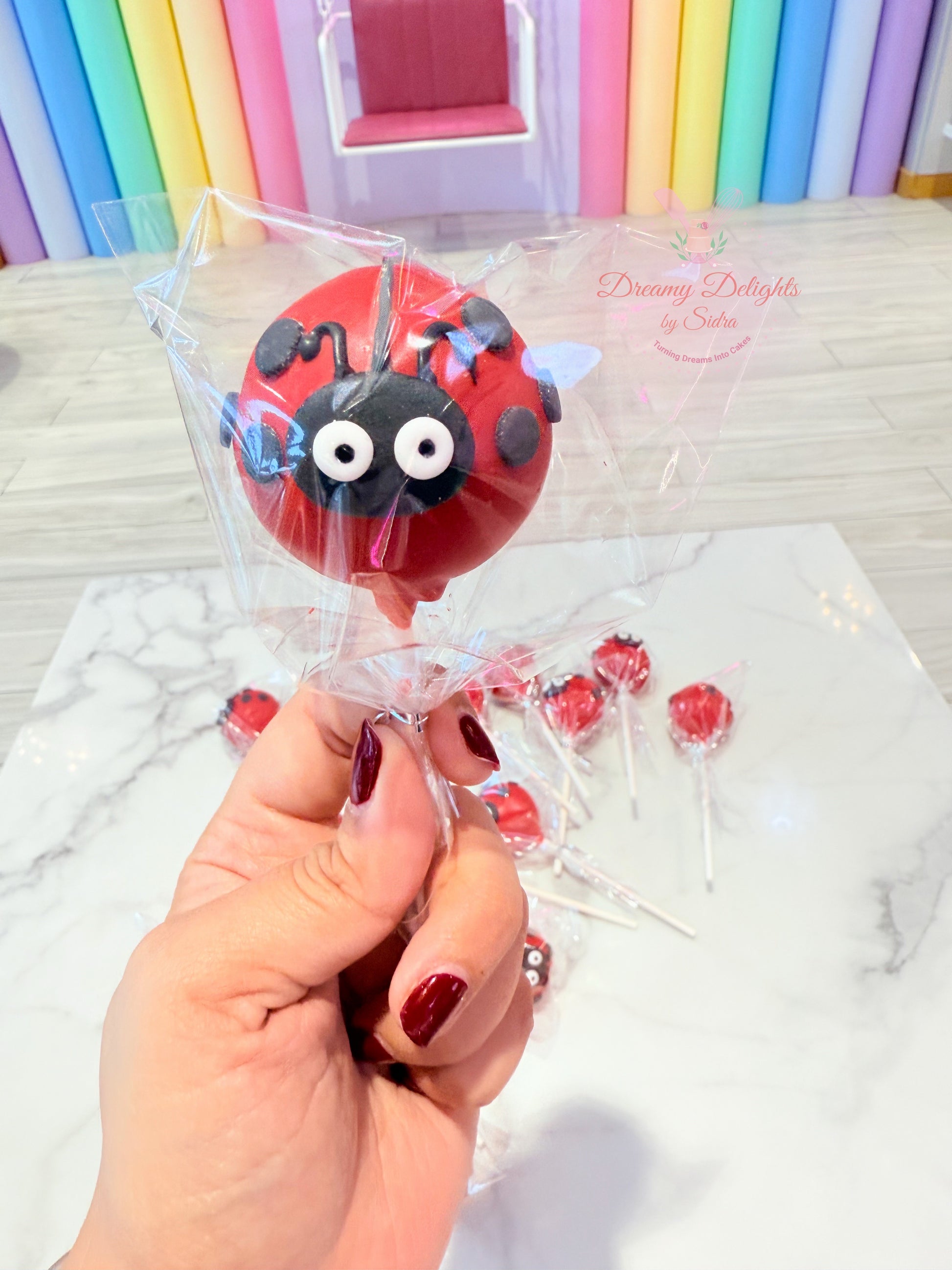 Ladybug themed cake pops for kids birthday party dessert table Dubai