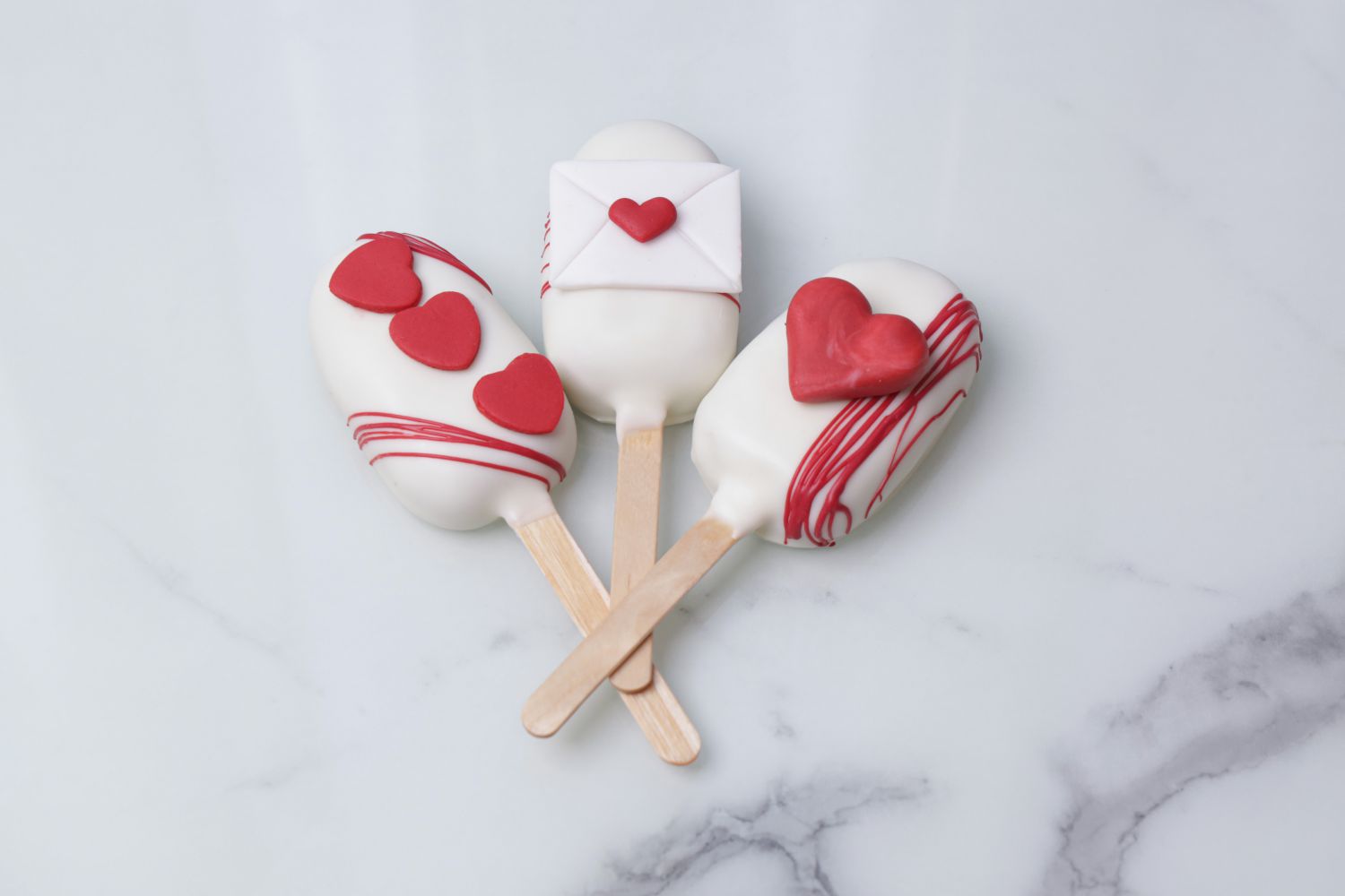 Love letter themed Valentine’s Day cakesicles with heart and envelope designs by Dreamy Delight by Sidra