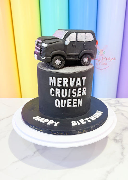 Black SUV-shaped cake with 'Mervat Cruiser Queen' text on a colorful background