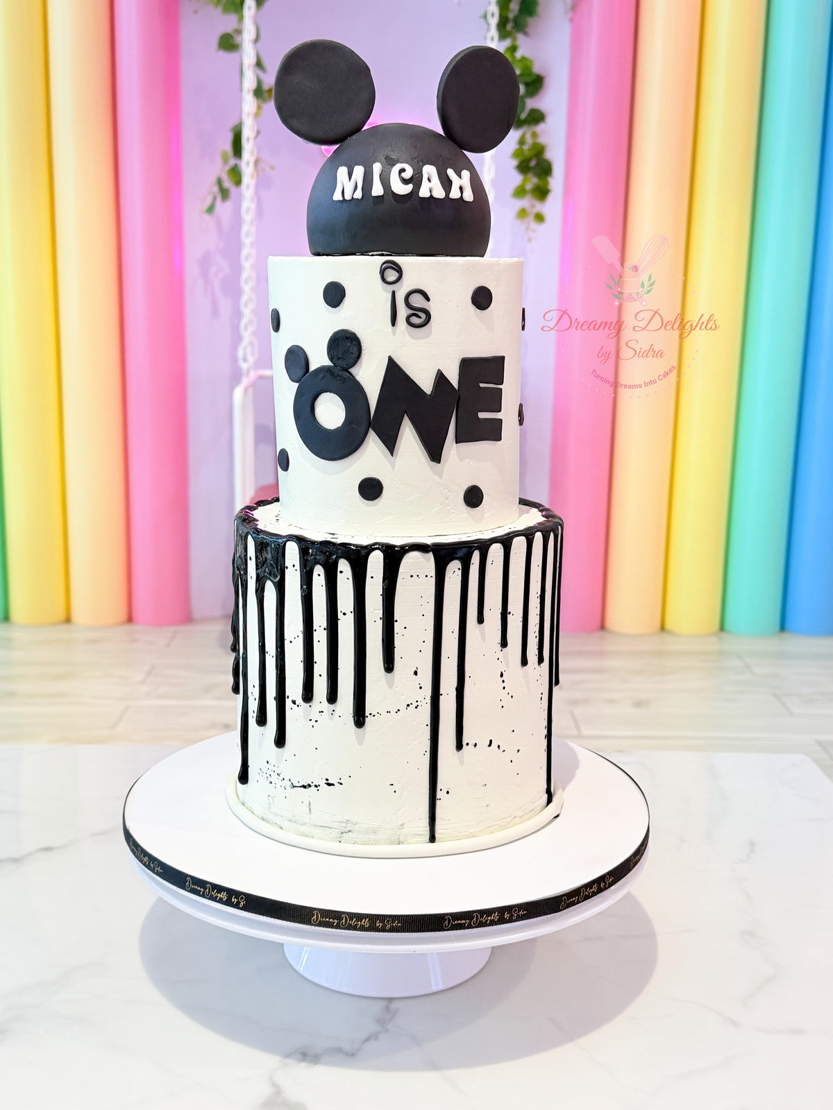 Mickey Mouse Cake with black mouse ears, white frosting, polka dots and black drip icing in Dubai