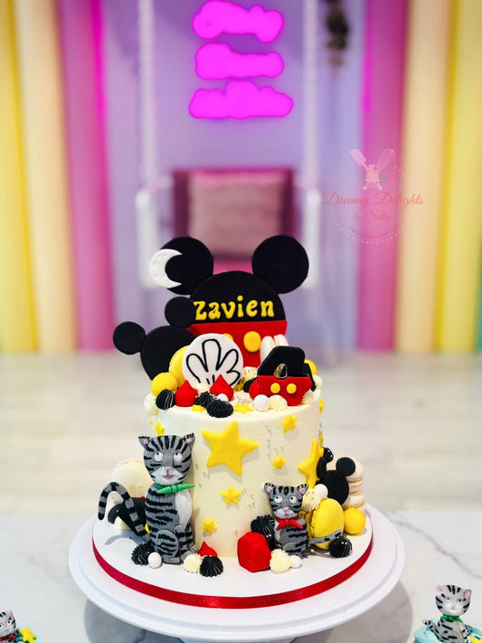Decorative cake with Mickey Mouse and cat figures against a colorful background