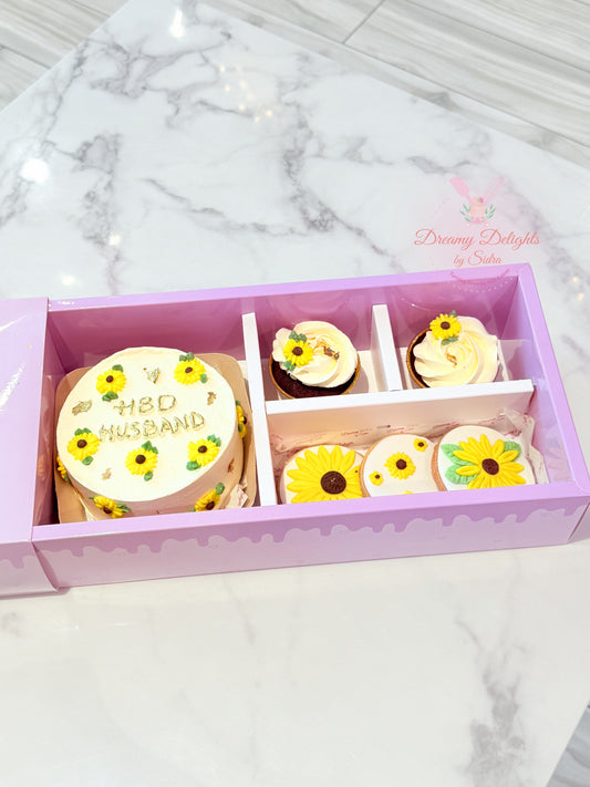 Decorative cookies with sunflower designs in a box on a marble surface