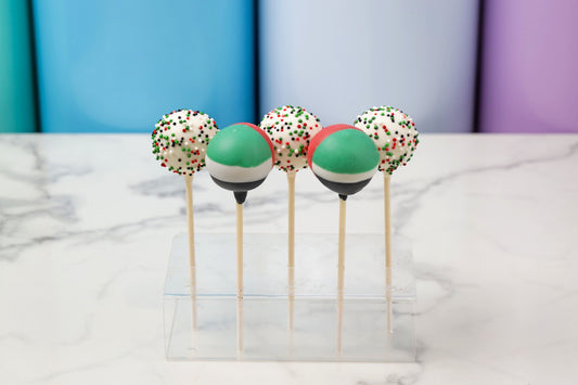 Colorful cake pops on sticks displayed on a marble surface with a colorful background