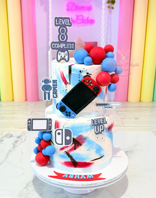 Gaming-themed birthday cake with a Nintendo Switch console on top, against a colorful background.