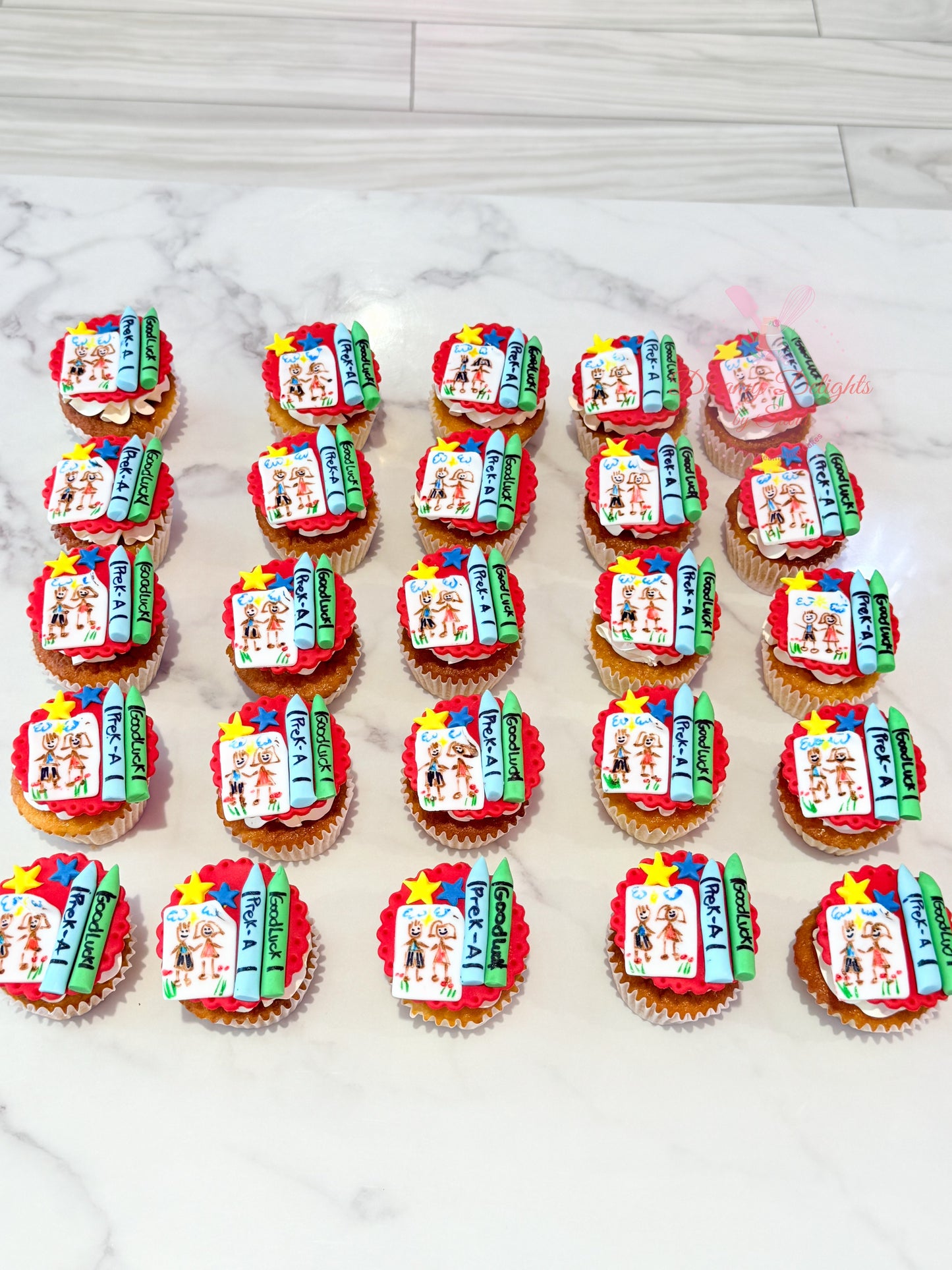Decorative cupcakes with colorful designs on a marble surface