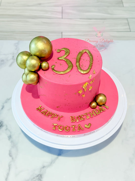 Pink and gold 30th birthday cake with smooth buttercream finish, gold detailing and custom name by Dreamy Delights by Sidra in Dubai