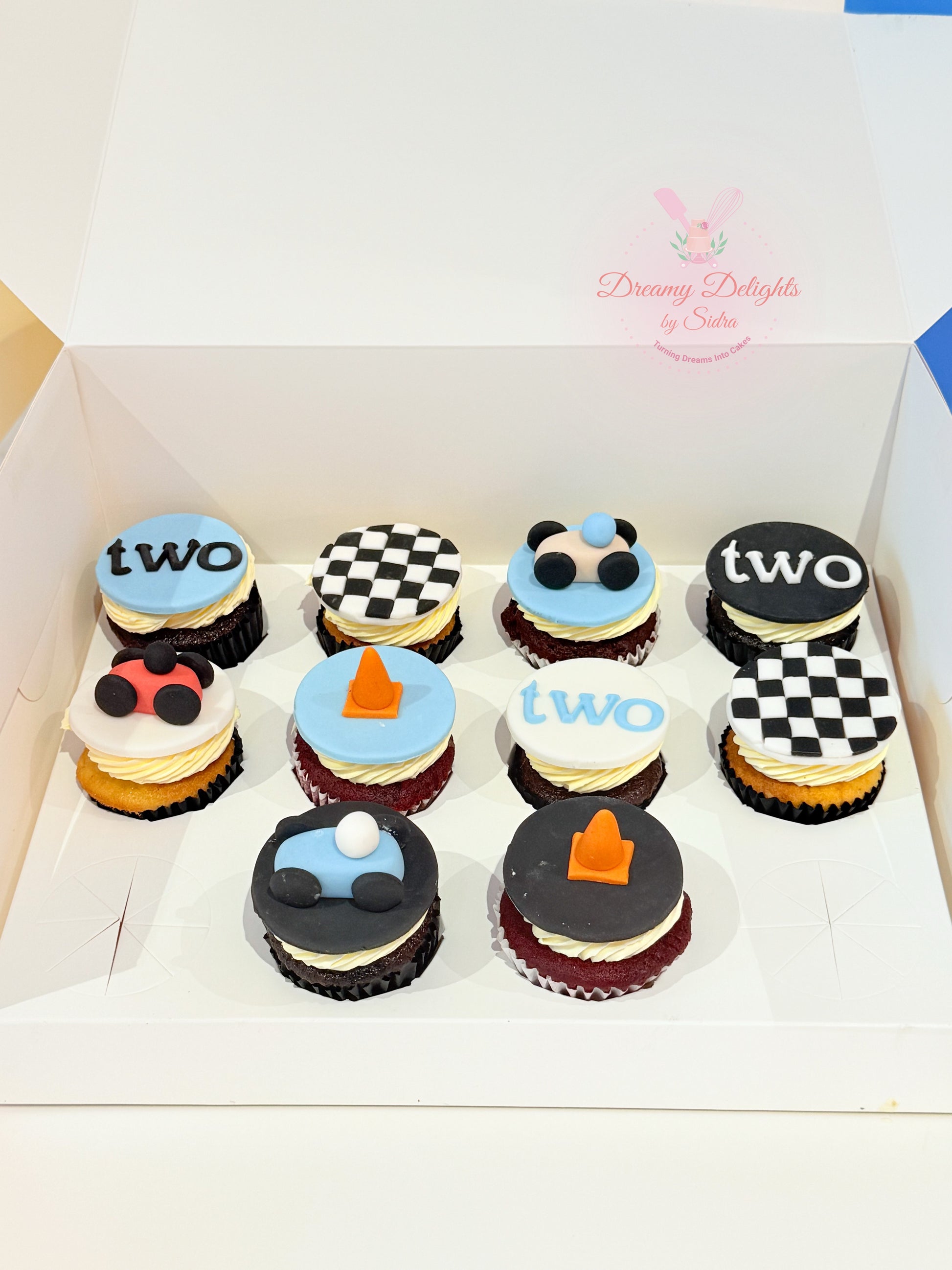 Racing car theme birthday cupcakes with fondant cars and checkered flag toppers for kids party in Dubai