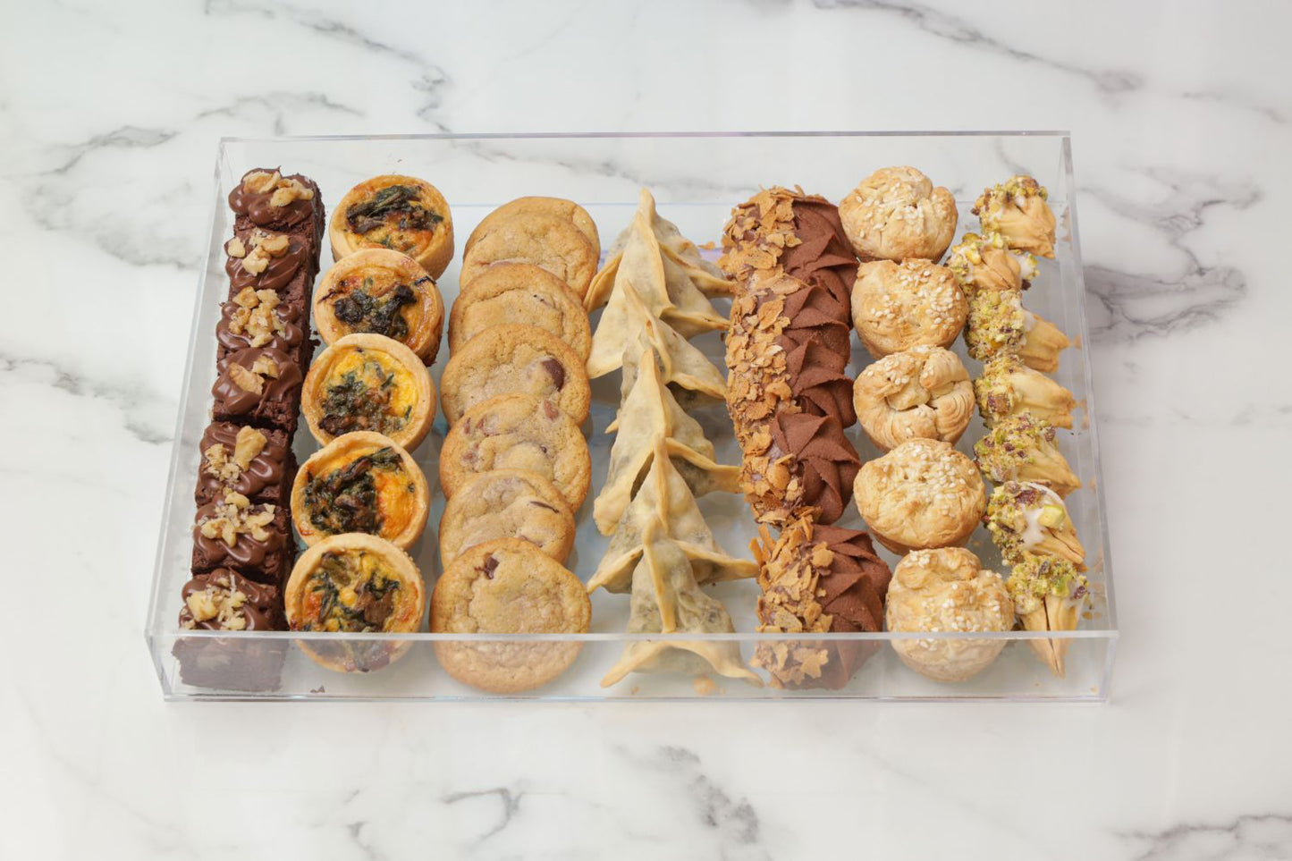 Ramadan acrylic tray with brownies mini quiche chocolate chip cookies fatayer chicken puffs and sable cookies Ramadan snack platter Dubai