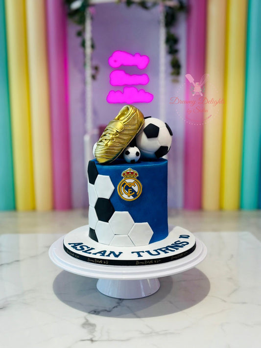 Real Madrid football cake Dubai with blue frosting, footballs and golden boot by Dreamy Delights by Sidra