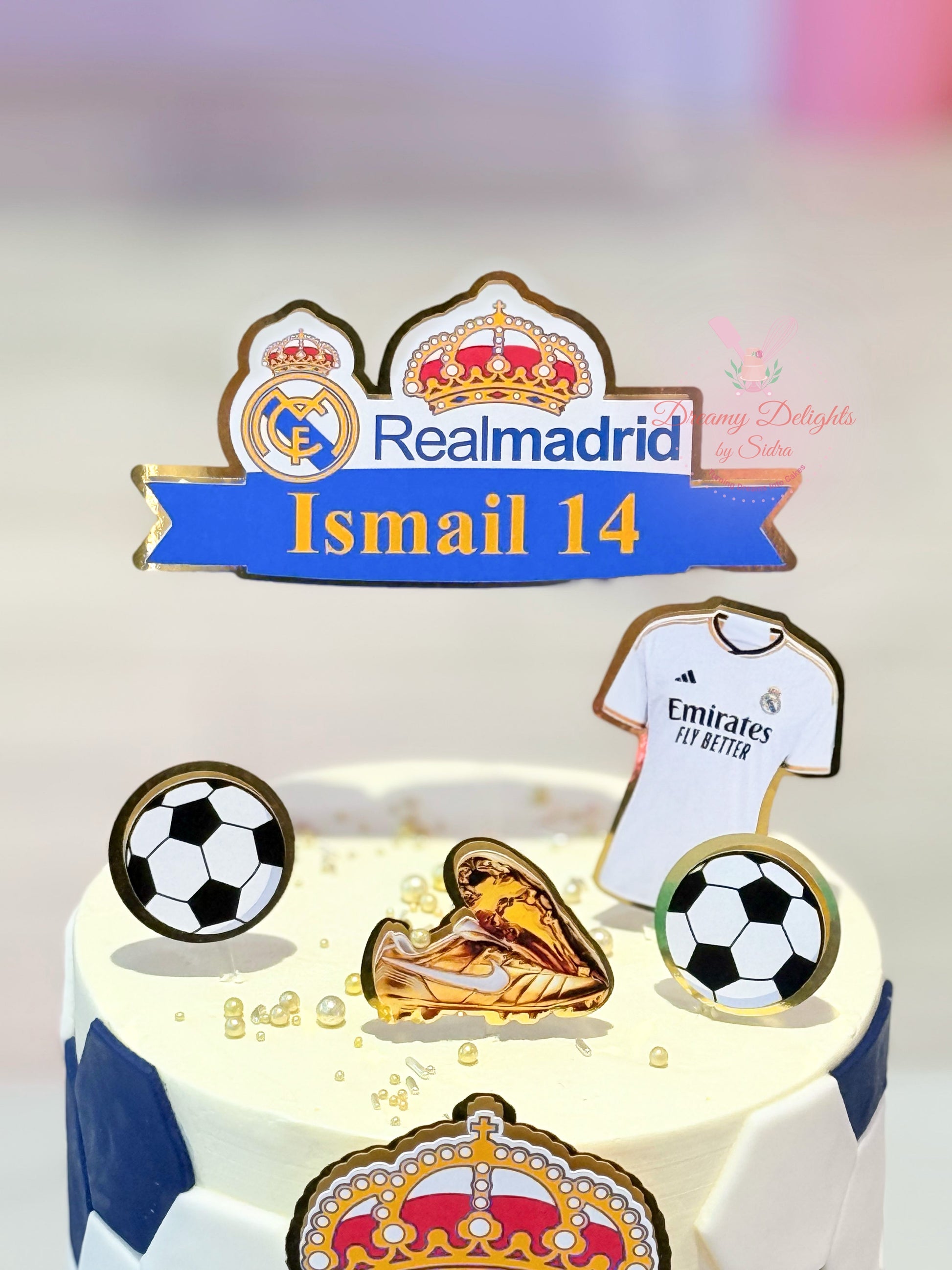 Real Madrid-themed birthday cake with soccer ball, jersey, and boot decorations.