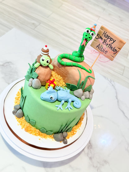 Birthday cake with animal-themed decorations on a white marble surface