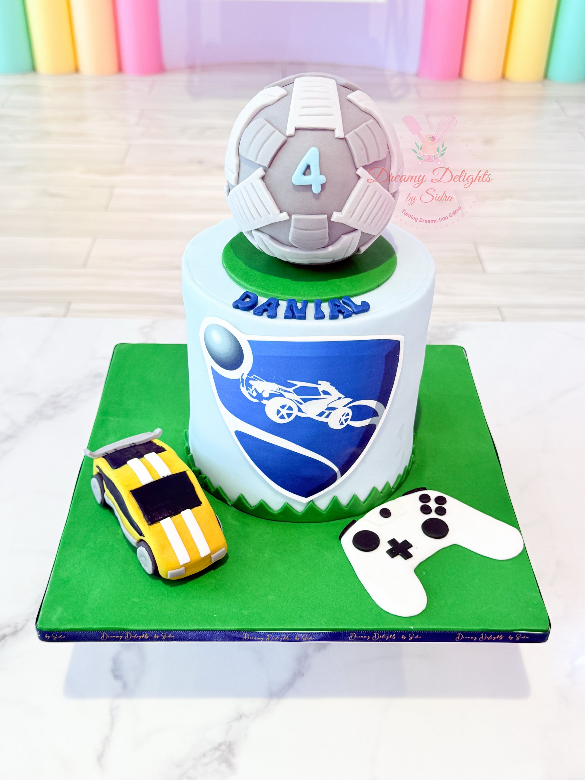 Rocket League cake for boys with gaming theme, car and football topper, controller design, and kids birthday celebration setup