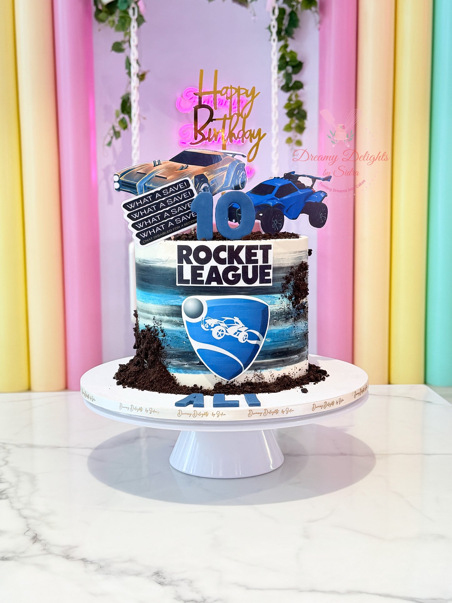 Rocket League gaming birthday cake with racing car toppers and blue gaming theme for boys celebrations in Dubai