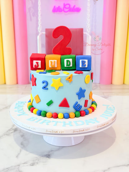 Shapes and numbers birthday cake with colorful blocks and geometric decorations for boys celebrations in Dubai