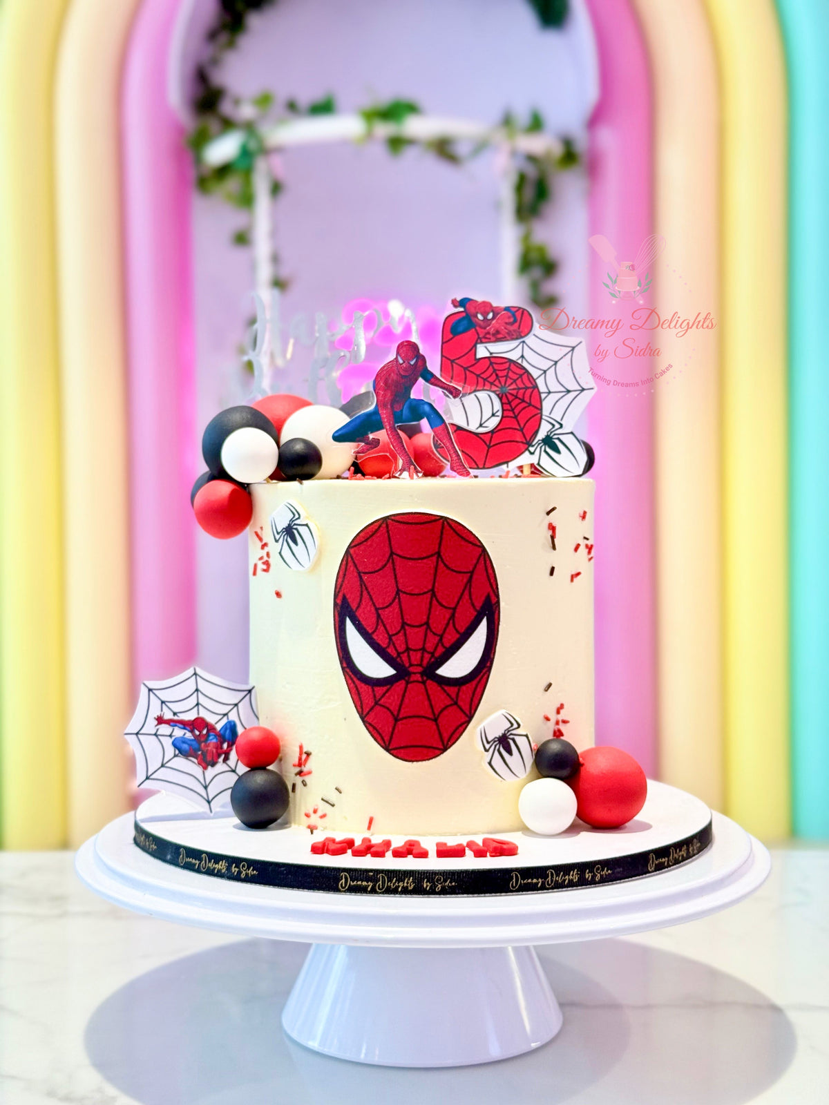 Spiderman cake for boys in Dubai with superhero figures, web details and red black design by Dreamy Delights by Sidra