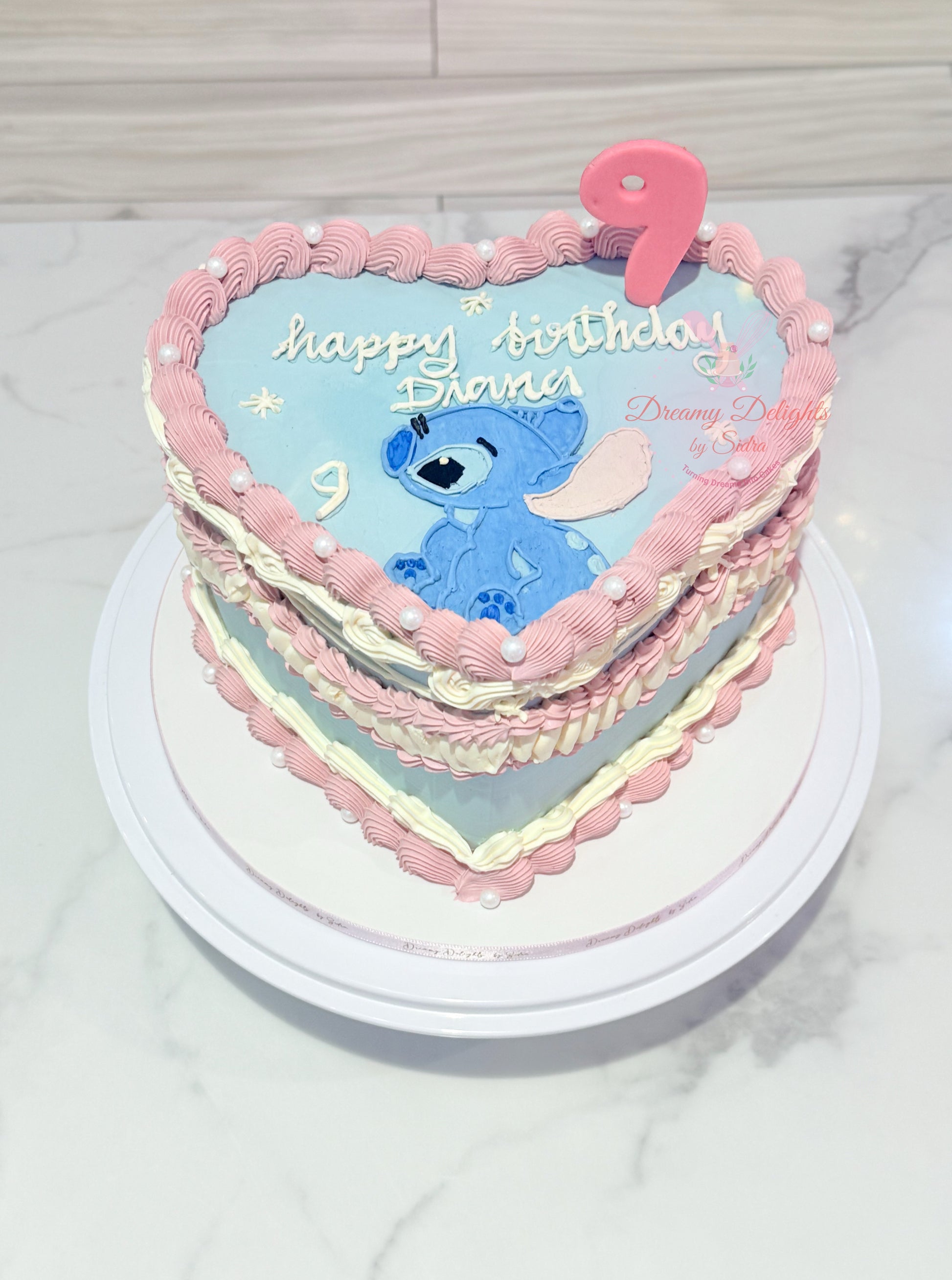 Heart-shaped birthday cake with cartoon character and 'Happy Birthday' text on a white surface.