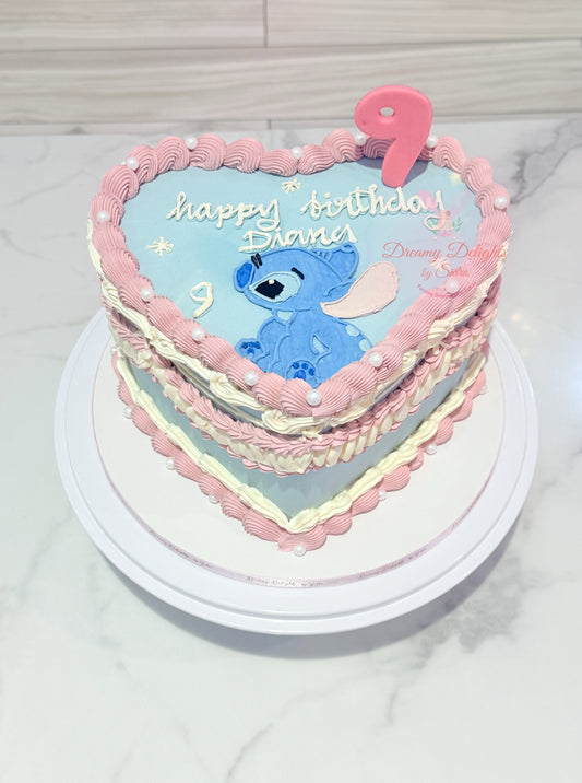 Heart-shaped birthday cake with cartoon character and 'Happy Birthday' text on a white surface.