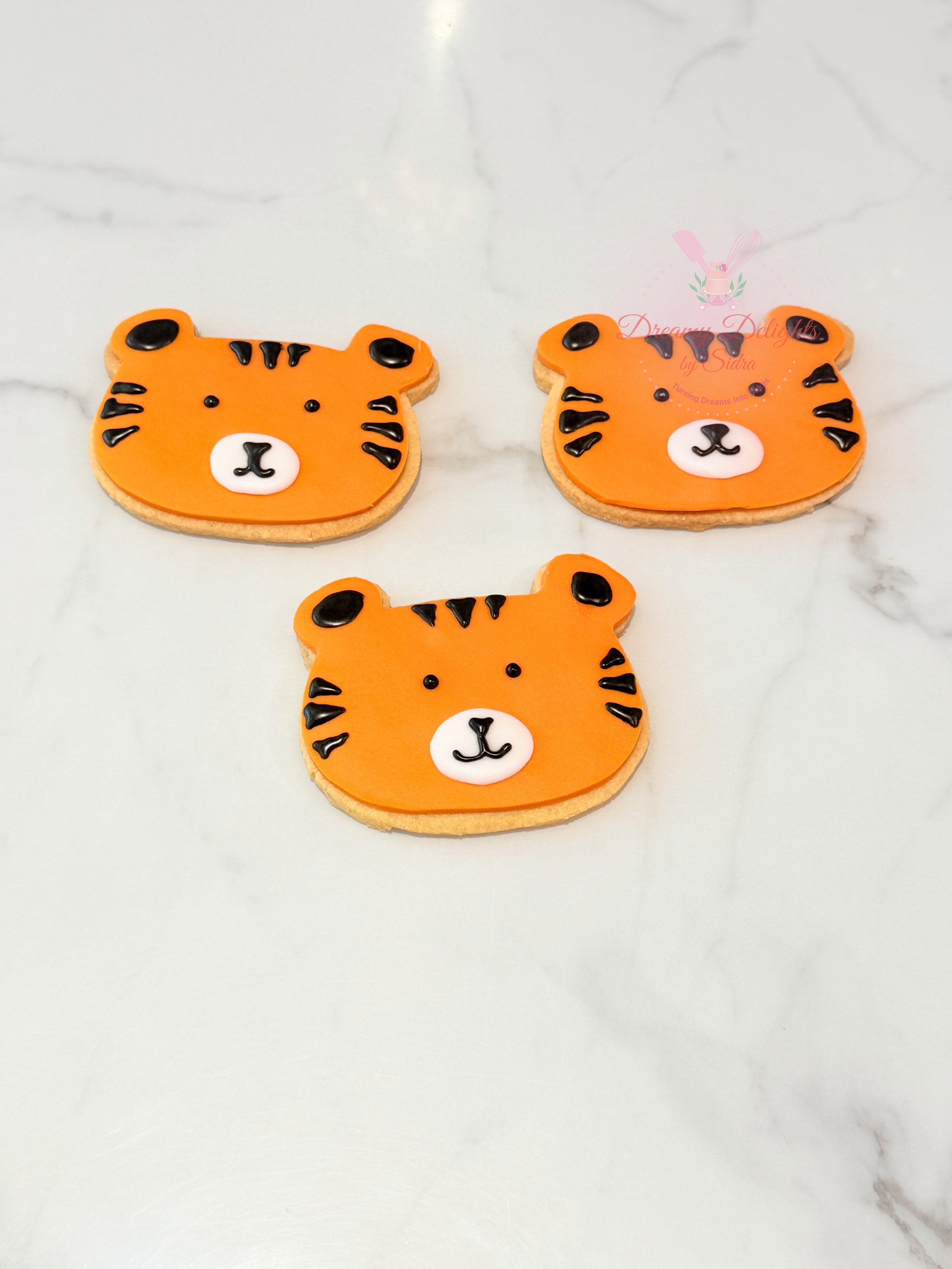 Tiger face cookies with fondant design for kids party favors and themed dessert table in Dubai