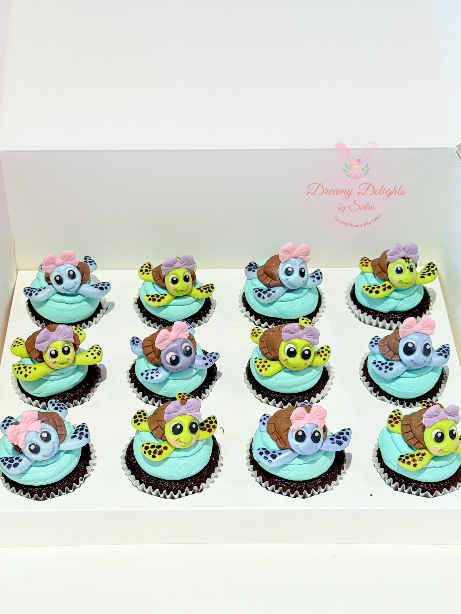 Cupcakes decorated with cartoon turtle characters on a white tray.