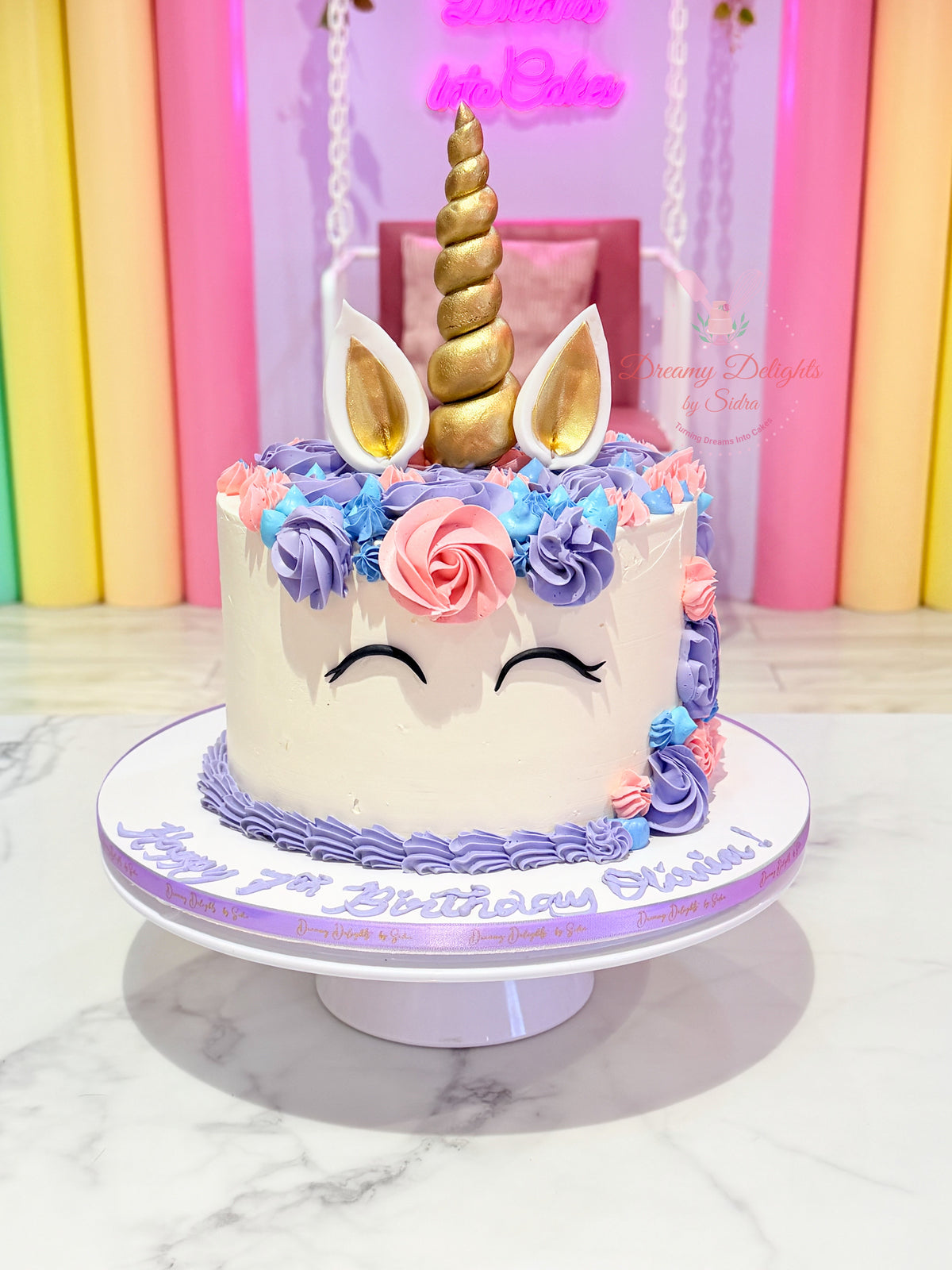 Unicorn cake Dubai with golden horn, pastel buttercream flowers and unicorn ears by Dreamy Delights by Sidra