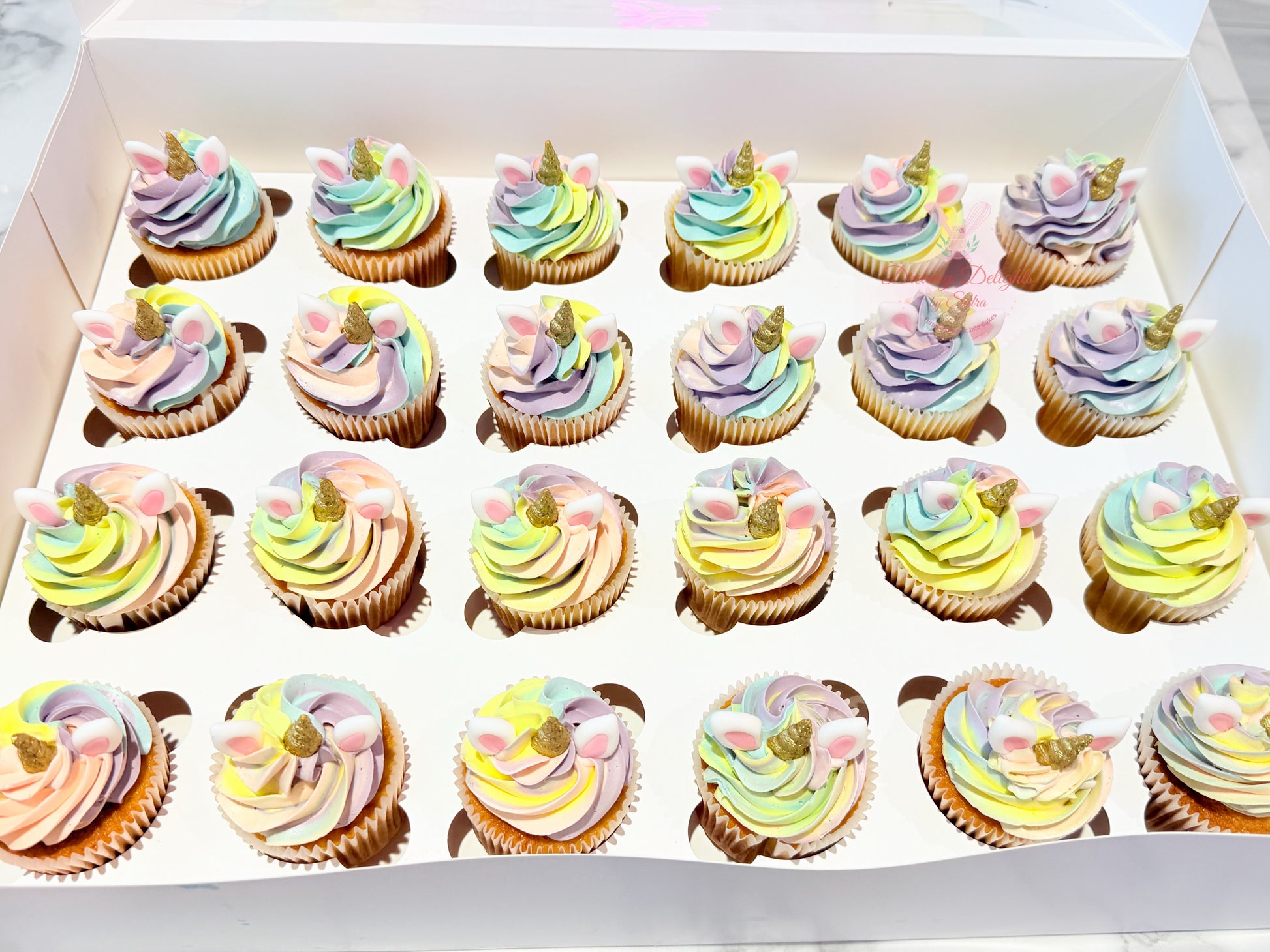 Pastel unicorn cupcakes with edible ears, golden horns, and colorful buttercream for birthday parties in Dubai.