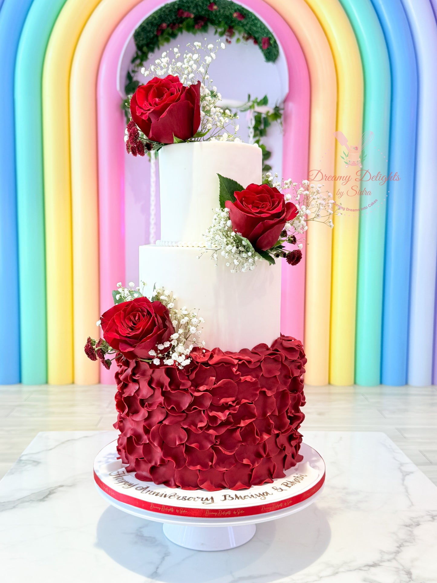 Three-tiered cake with red floral wedding anniversary cake